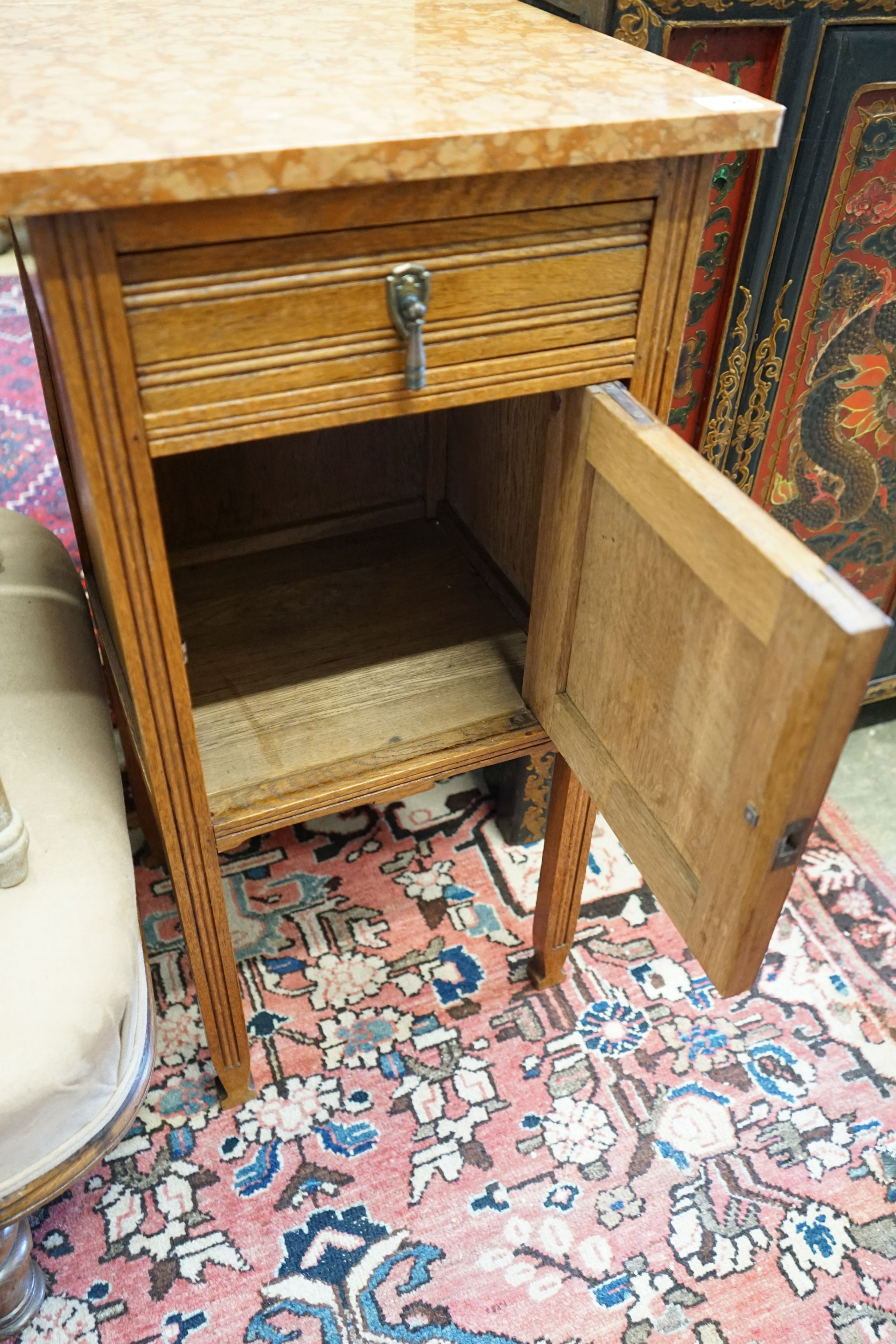 A pair of early 20th century marble topped carved oak bedside cabinets, width 42cm, depth 38cm, height 82cm
